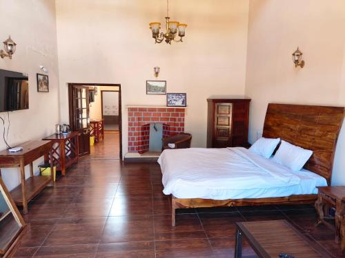 a bedroom with a bed and a desk and a television at Heritage Inn by Brown Tree Resorts in Ooty