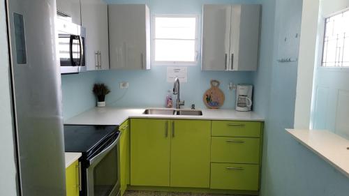 a kitchen with green cabinets and a sink at Casa Laguna Unit 6, Spacious 3BR Near Beach and Restuarants in San Juan