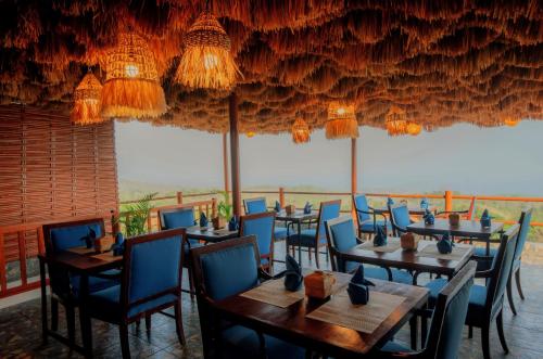 Mere Sea View Resort & Spa في Batununggul: مطعم به طاولات وكراسي وثريات