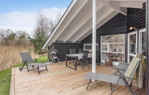a deck with chairs and a table and a grill at Holiday Home Fasanvej Xii in Humble