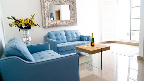 uma sala de estar com cadeiras azuis, uma mesa e um espelho em Boutique Hotel Las Flores Punta Cana em Punta Cana