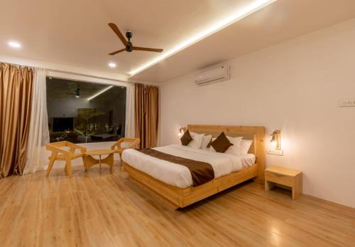 a bedroom with a bed and a desk in it at RUSTIC VOGUE in Shamirpet