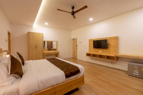 a bedroom with a bed and a flat screen tv at RUSTIC VOGUE in Shamirpet