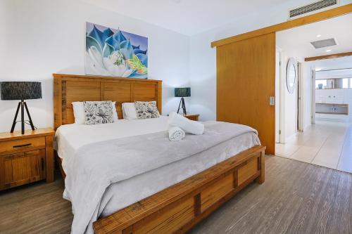 a bedroom with a large bed with a laptop on it at Best at Bright Point Absolute Waterfront Apartment in Nelly Bay