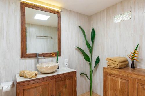a bathroom with a sink and a mirror at Desaku Bungalows in Canggu