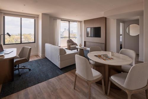 a hotel room with a table and chairs and a living room at Rydges North Sydney in Sydney