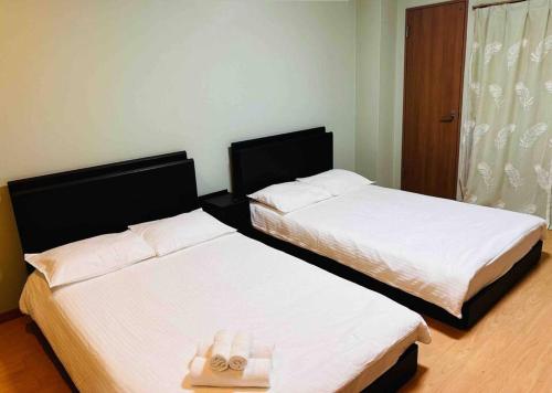 Dos camas una al lado de la otra en una habitación. en 全新上线花跡民宿5号館102 独享空间 难波，日本桥4分钟车程！天王寺，通天阁步行圈！, en Osaka