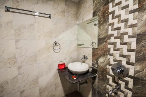 a bathroom with a sink and a shower at OYO Home Hotel Skyland in Ahmedabad