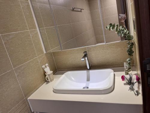 ein weißes Waschbecken im Bad mit Spiegel in der Unterkunft Vinhomes Metropolis 1Br Mai-homestay in Hanoi