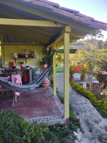 a hammock on a patio under a pergola at Hotel Kira in Jericó