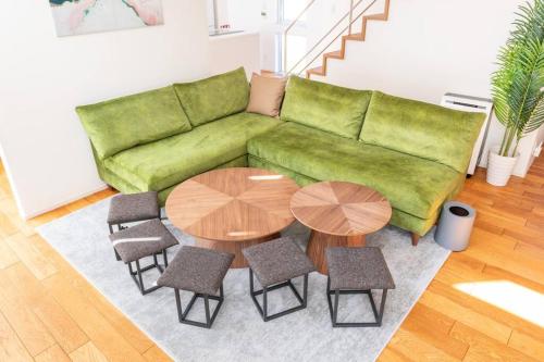 a living room with a green couch and a table at One house Naganuma MAOI in Naganuma