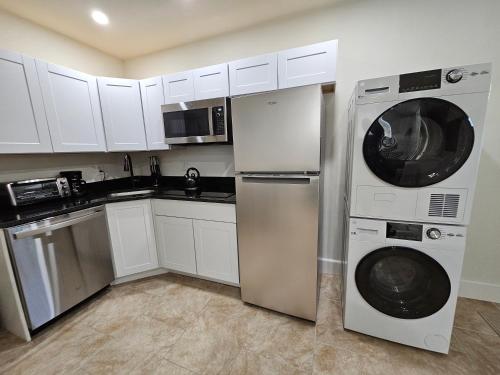 a kitchen with white cabinets and a washer and dryer at 1-Bedroom Apt-9W1 20-Minuite To Downtown Boston in Boston
