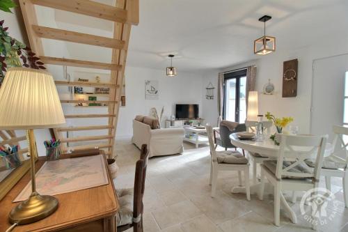 - un salon avec un escalier, une table et des chaises dans l'établissement Le bon temps, à Pleubian