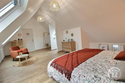 una camera da letto con un letto grande e una sedia di Le bon temps a Pleubian