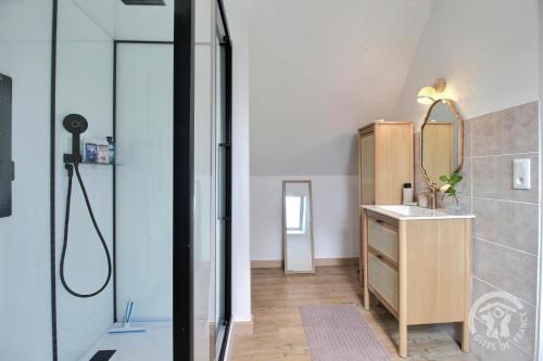 un bagno con doccia, lavandino e specchio di Le bon temps a Pleubian