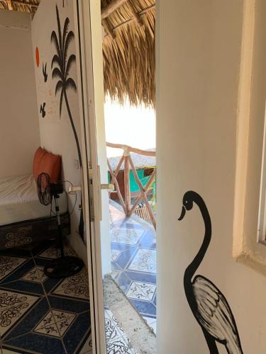 una puerta que conduce a una habitación con un cisne negro en la pared en Cuarto Palma en El Paredón Buena Vista