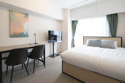 a bedroom with a bed and a desk with chairs at Fujiterrace Yoga in Tokyo