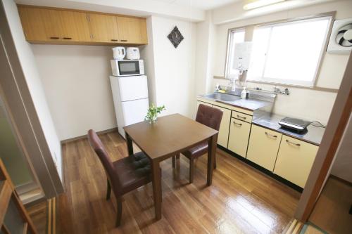 a small kitchen with a table and a sink at 高原マンション 201 in Matsuyama
