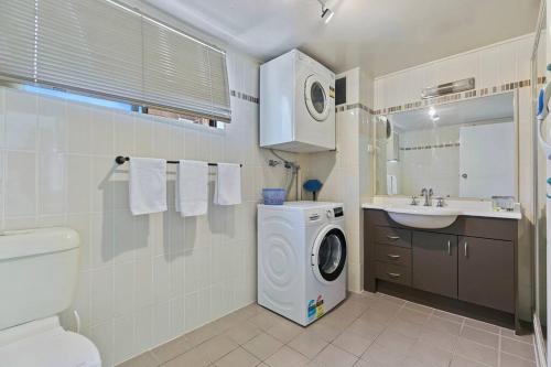 a bathroom with a washing machine and a sink at Bongaree Water's View in Bongaree