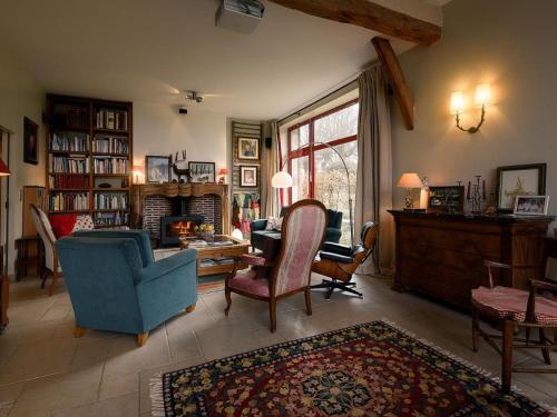 ein Wohnzimmer mit einem blauen Sofa und Stühlen in der Unterkunft Gîte Le Brethon, 7 pièces, 12 personnes - FR-1-489-499 in Le Brethon