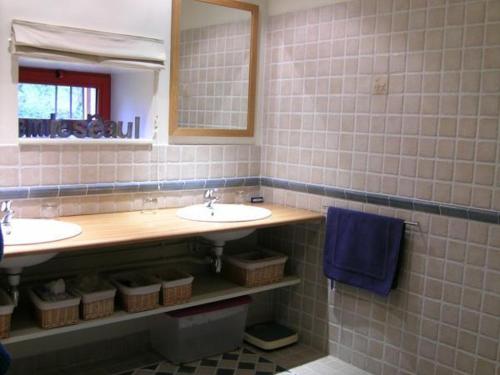 ein Badezimmer mit 2 Waschbecken, einem Spiegel und einem blauen Handtuch in der Unterkunft Gîte Le Brethon, 7 pièces, 12 personnes - FR-1-489-499 in Le Brethon