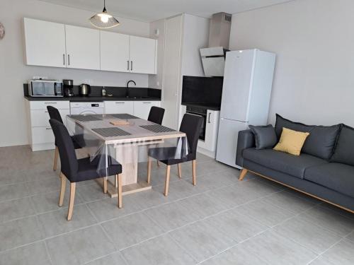 - une cuisine et une salle à manger avec une table et un canapé dans l'établissement Appartement Neuf Proche Plage et Commerces, Quartier Des Demoiselles, Saint-Jean-de-Monts - FR-1-323-512, à Saint-Jean-de-Monts