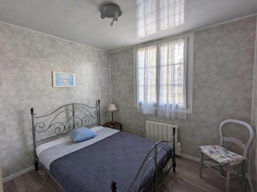 une chambre avec un lit, une chaise et une fenêtre dans l'établissement Charmant T3 avec Terrasse et WIFI, proche Port à Arcachon - FR-1-420-142, à Arcachon