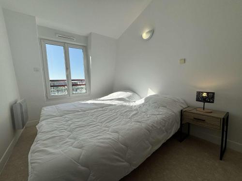 - une chambre blanche avec un lit et une table avec une lampe dans l'établissement Spacieux appartement 2 chambres avec parking à Rochefort - FR-1-246B-50, à Rochefort