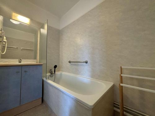 une salle de bain avec une baignoire et un lavabo dans l'établissement Spacieux appartement 2 chambres avec parking à Rochefort - FR-1-246B-50, à Rochefort
