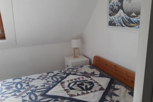 une chambre avec un lit avec une couette dessus dans l'établissement BRIGHT AND QUIET APARTMENT 5 MNS FROM THE BEACH, à Carnac