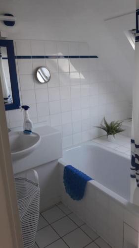 une salle de bain avec une baignoire blanche et un lavabo dans l'établissement BRIGHT AND QUIET APARTMENT 5 MNS FROM THE BEACH, à Carnac