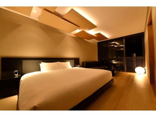 a bedroom with a large white bed and a living room at MOGANA - Vacation STAY 59289v in Kyoto