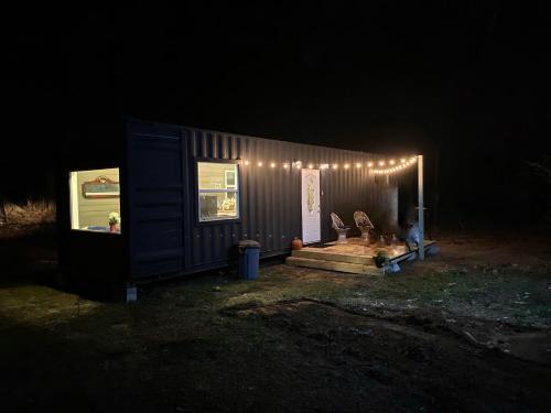 a tiny house with lights on it at night at Tiny House Oasis: Nature Escape in Nacogdoches