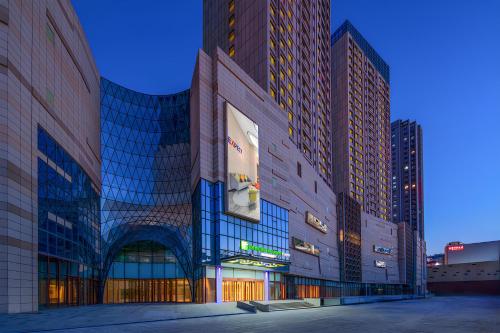 ein großes Gebäude mit hohen Gebäuden in einer Stadt in der Unterkunft Holiday Inn Express Weifang City Center, an IHG Hotel in Weifang