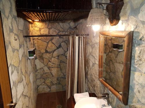 a stone bathroom with a shower and a toilet at Hotel Rincon Huasteco in Ciudad Valles