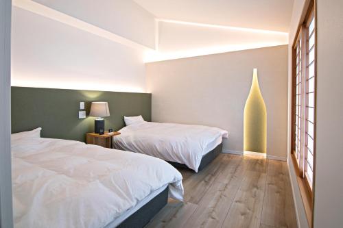 Postel nebo postele na pokoji v ubytování Forest Guardian Hotel 京都御所西