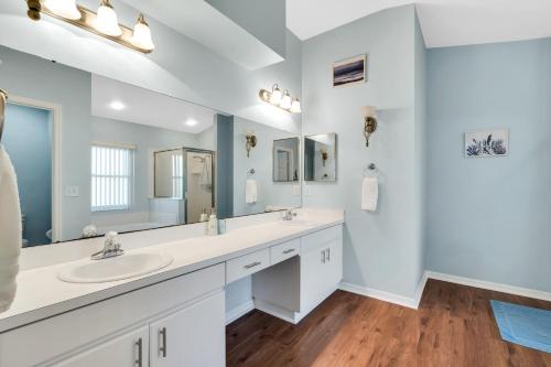 ein Badezimmer mit zwei Waschbecken und einem großen Spiegel in der Unterkunft Happy place! 2 king beds, hot tub, free parking in Riverview