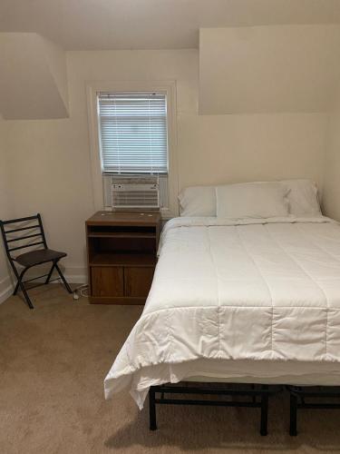 um quarto com uma cama, uma secretária e uma janela em Cozy Home on North Pine em Lansing