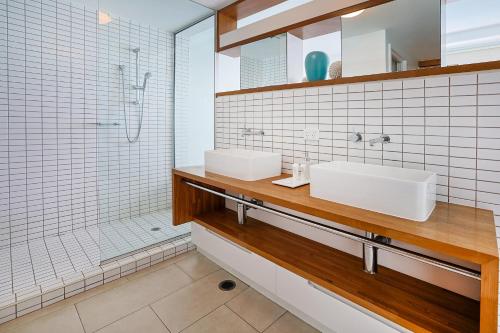 a bathroom with two sinks and a shower at Best at Bright Point Absolute Waterfront Apartment in Nelly Bay