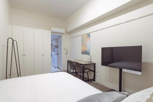 a bedroom with a bed and a desk and a tv at Fujiterrace Yoga in Tokyo