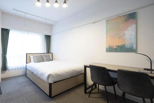 - une chambre avec un lit, un bureau et une table dans l'établissement Fujiterrace Yoga, à Tokyo