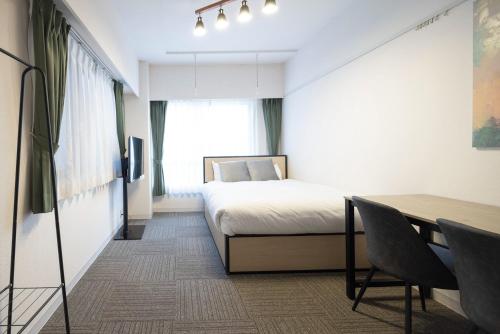 Schlafzimmer mit einem Bett, einem Schreibtisch und einem Tisch in der Unterkunft Fujiterrace Yoga in Tokio