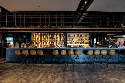 a bar with a bunch of stools in a room at Sage Melbourne Ringwood in Ringwood