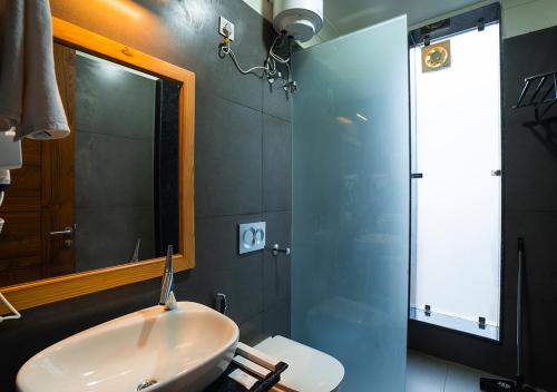 a bathroom with a sink and a mirror and a shower at Moustache Bhimtal Luxuria, Nainital in Bhīm Tāl