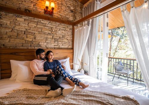 a man and a woman sitting on a bed at Moustache Bhimtal Luxuria, Nainital in Bhīm Tāl
