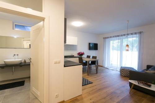 a kitchen and living room with a sink and a table at Parksuites Apartments Graz in Graz