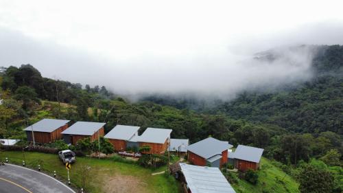 eine Gruppe von Häusern an der Seite eines Berges in der Unterkunft Happy camp phuchifa แฮปปี้แคมป์ ภูชี้ฟ้า in Ban Huai Han