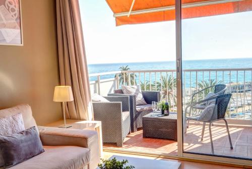 een woonkamer met uitzicht op de oceaan bij La Gioia 3 by Hello Homes Sitges in Sitges