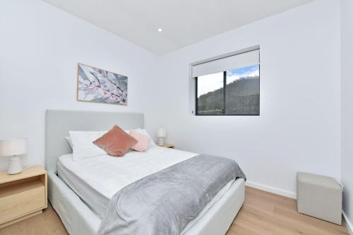 a white bedroom with a bed and a window at Somerville Wines Lux Escape 3-Bedroom Cottage Near Broke Wineries in Broke