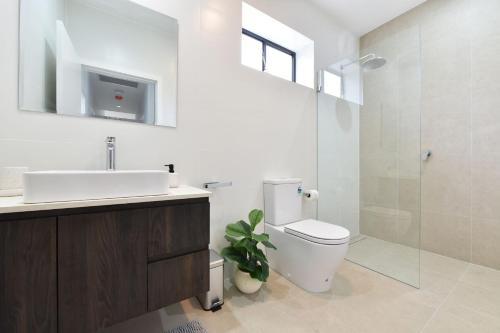 a bathroom with a toilet and a sink and a shower at Somerville Wines Lux Escape 3-Bedroom Cottage Near Broke Wineries in Broke